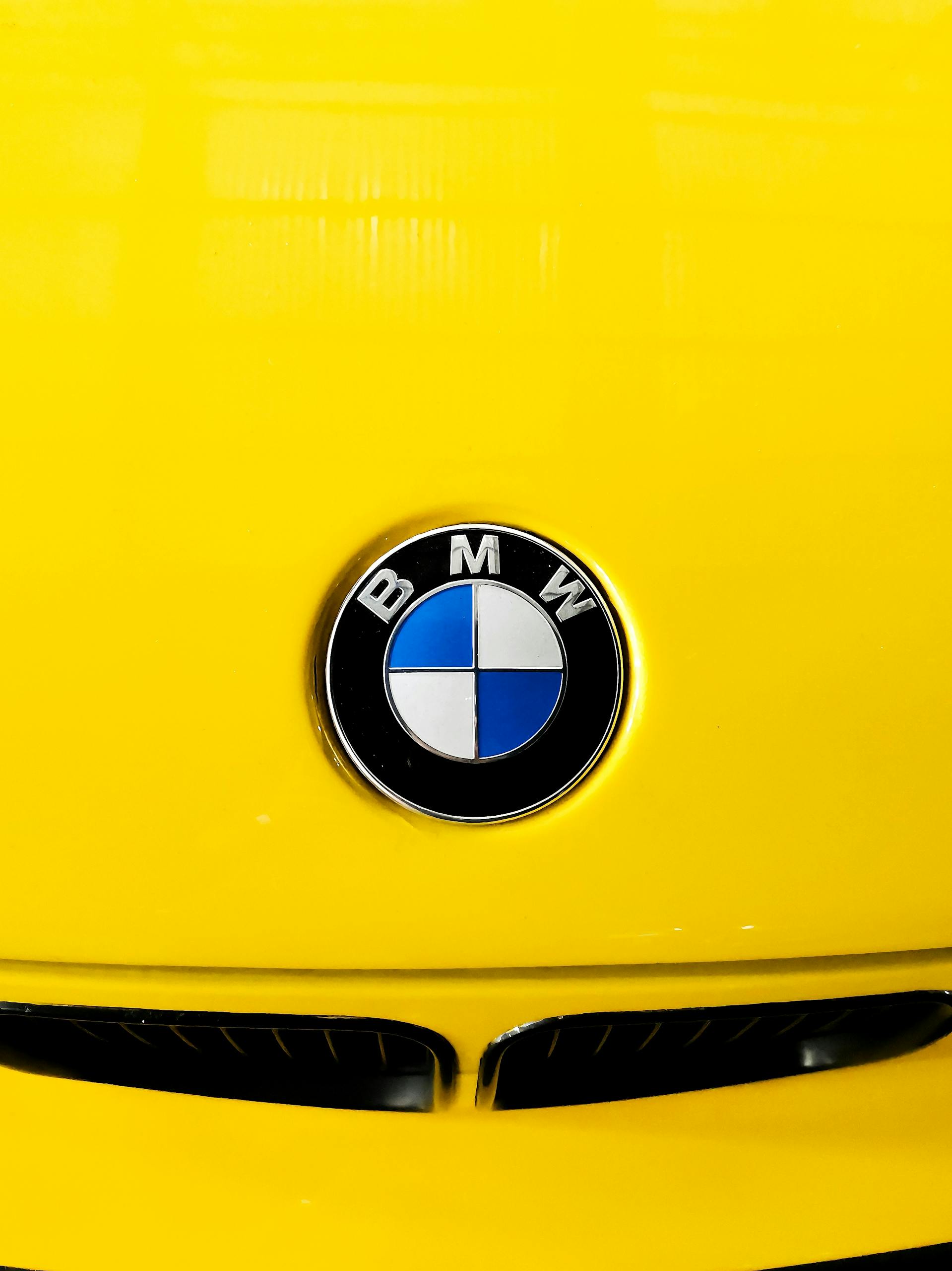 Bright yellow BMW car hood with iconic emblem, shot in Kochi, India.