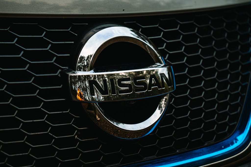 Detailed shot of the Nissan logo on a car grille grid, emphasizing automotive branding.